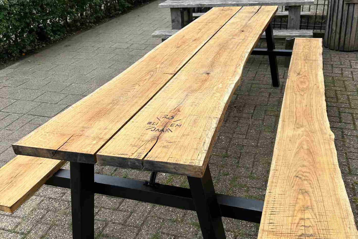 Zwart stalen, klassiek A frame picknicktafel met houten zittingen en blad. 